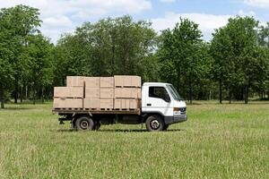 A truck is driving through a field with boxes on it photo