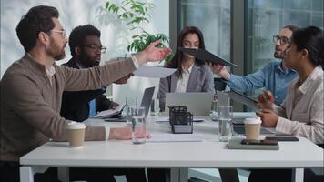 Multinational diversity Caucasian Indian team businesswomen businessmen business company men women briefing colleagues discuss project plan strategy in office sharing papers documents meeting partners video