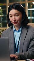 Asian Korean business woman female in office businesswoman talking call online meet using laptop computer operator Chinese Japanese girl manager executive in headphones speaking support center video