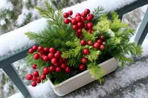Christmas decoration with red berries and green branches resting on snowy railing photo