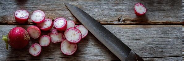 Sliced Radishes and a Knife on a Rustic Wooden Surface Prepared for a Meal photo