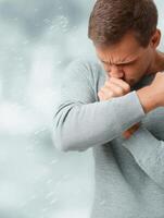Male Figure Sneezing Into Elbow With Blurred White Background During Daytime Health Awareness Moment photo