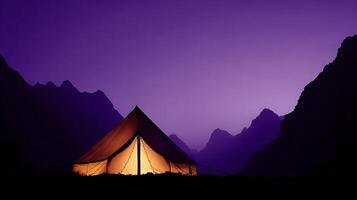 Cozy Tent Illuminated Against Majestic Mountain Peaks at Dusk. photo