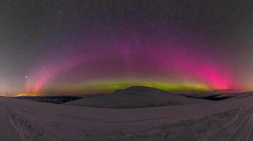 Majestic Aurora Borealis Paints the Starry Arctic Sky Over Snowy Peaks. photo