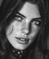 Close-up portrait of a young woman with freckles in black and white photo