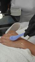 A special cooling gel is applied to the young woman's hand prior to starting the hardware photoepilation procedure. Vertical. video