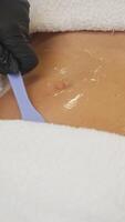 Abdomen of young woman is coated with gel prior to starting procedure for body shaping, reducing cellulite, improving skin tone, promoting lymph flow, and accelerating metabolic processes. video