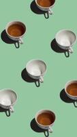 Pattern with many tea cups and empty cups animated on light green background. Tea mugs with hot drink move in different directions. vertical footage video