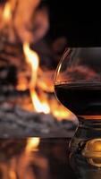 Glass with whiskey or cognac. Burning Fire In The Fireplace. Warmth and home comfort, vertical footage video