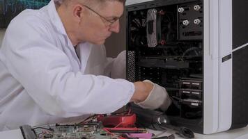Man in lab coat works on internal components of PC system with tools and gloves video