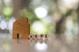 House model with spelling the word home on wood circle block. mortgage for a home. photo