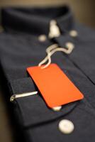 A red blank label tag on folded blue shirts for promotion and advertising. The concept of shopping photo