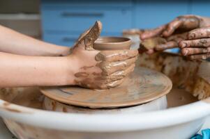 A person is making a pot on a potter's wheel photo