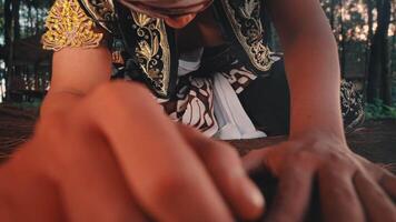 Javanese Dancer Kneeling to Touch a Sprout on the Ground video