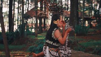 Traditional Javanese Performer Kneeling with Batik in Forest video