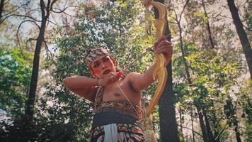 Focused Javanese Archer Drawing Bow with Jasmine Flowers video