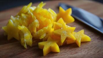 Bright Yellow Star-Shaped Peppers Sliced for Kids Menu Presentation in a Kitchen Setting Near a Knife on a Wooden Cutting Board photo