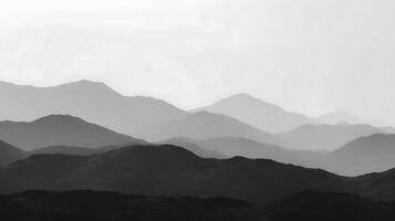 Majestic mountain range silhouettes under a hazy sky. photo