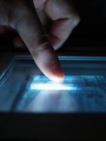 Digital Scratch Card Glowing Brightly Under Finger Swipe, Revealing Details in a Darkened Setting for an Engaging User Experience photo