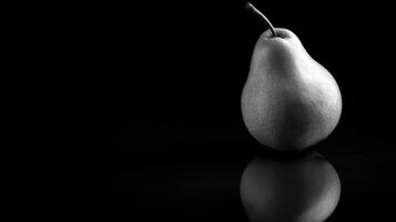Single Pear Illuminated by Dramatic Lighting on Reflective Black Glass With a Blank Top Margin During a Still Life Setting photo