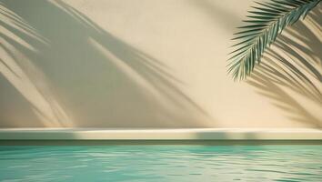 Palm leaf shadows cast on a neutral wall above a tranquil swimming pool photo
