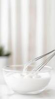 Elegant Close-Up of Fresh Cream Being Whisked in a Clear Glass Bowl, Highlighting Culinary Preparation and Smooth Texture for Delicious Desserts. photo