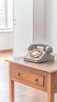 A captivating glimpse into the past an exquisite vintage rotary telephone rests gracefully on an aged wooden table, evoking timeless communication photo