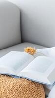 Immerse in literary tranquility with an open book on a cozy sofa, perfect for a peaceful reading escape and moments of quiet contemplation. photo