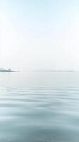 Expansive Serenity A Minimalist Vista of Calm Blue Waters and a Distant Horizon Under a Soft, Clear Sky, Evoking Tranquil Reflection. photo