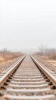 Misty Morning Railway Tracks Disappearing into the Foggy Horizon, a Serene and Evocative Landscape of Endless Journey and Quiet Solitude photo
