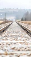 Captivating Perspective Railway Tracks Converging into a Hazy Horizon Across a Serene Countryside Landscape, Evoking Journey and Tranquility. photo