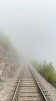A Captivating View of Railway Tracks Disappearing into a Thick Blanket of Fog, Evoking a Sense of Mystery and Serene Journey Through a Misty Landscape photo