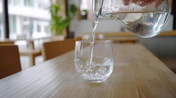 Crystal Clear Water Pouring into a Glass on a Wooden Table A Refreshing Moment of Purity and Hydration Indoors photo