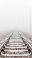 Misty Morning Railway A Vanishing Perspective of Train Tracks Disappearing into Dense Fog, Evoking a Sense of Calm and Endless Journey. photo