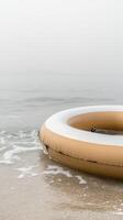 Serene Beach Scene with Inflatable Ring Perfect for Summer Leisure and Relaxation by the Ocean's Gentle Waves. A Tranquil Coastal Escape photo