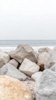 Serene Coastal Landscape with Rugged Grey Rocks and Gentle Ocean Waves Under a Soft Sky, Evoking Natural Tranquility and Earthy Beauty. photo