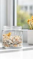 Serene Still Life Dried Botanical Potpourri in a Clear Glass Jar Bathed in Gentle Sunlight, Enhancing Home Decor with Natural Elegance. photo