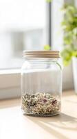 Close-up of Dried Botanical Herbs and Floral Petals in a Transparent Glass Mason Jar Bathed in Natural Sunlight on a Wooden Surface photo