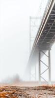 Ethereal Bridge Structure Piercing Through Dense Fog A Muted Architectural Grandeur Amidst a Serene, Atmospheric Landscape View photo