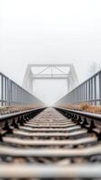 Ethereal railway bridge emerges from dense fog, a mysterious path into the unknown. A serene and atmospheric journey along the tracks, disappearing into the misty horizon. photo