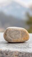 A captivating natural stone, weathered and smooth, rests serenely on a textured surface, embodying tranquility and the enduring beauty of the earth's elements. photo