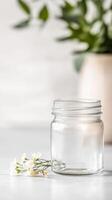 Pristine Clear Glass Jar with Delicate White Blossoms A Serene Still Life Composition, Capturing Simplicity and Natural Elegance in a Bright Setting photo