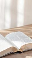 Serene Open Book on Wooden Table Bathed in Natural Light, Symbolizing Spiritual Study, Wisdom, and Peaceful Contemplation photo