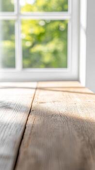 Luminous wooden tabletop bathed in morning light, framing a vibrant, blurred natural vista through a pristine window. An idyllic, tranquil setting. photo