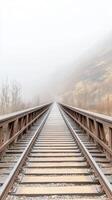 Misty railway bridge extends into the vanishing fog, a serene and atmospheric journey through a desolate mountain landscape. Captivating endless tracks. photo
