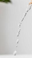 Captivating Close-Up of Pure Water Flowing and Dripping, Showcasing Crystal Clear Liquid in Dynamic Motion Against a Serene Background. photo