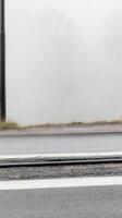 A Moody Morning Dense Fog Obscures the Horizon Over a Wet Road and Tram Track, Creating a Serene and Mysterious Urban Landscape. photo