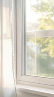 Tranquil Home Scene Elegant White Window with Sheer Curtains, Flooded with Warm Natural Light, Overlooking a Lush Green Landscape photo
