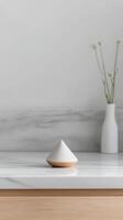Elegant minimalist home decor, featuring a modern white and wood geometric object on a pristine marble counter, creating a serene and clean interior aesthetic. photo