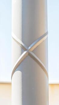 arquitectónico detalle de un moderno texturizado apoyo columna con un distinto cruzado patrón, iluminado por natural luz, exhibiendo urbano diseño y material forma. foto